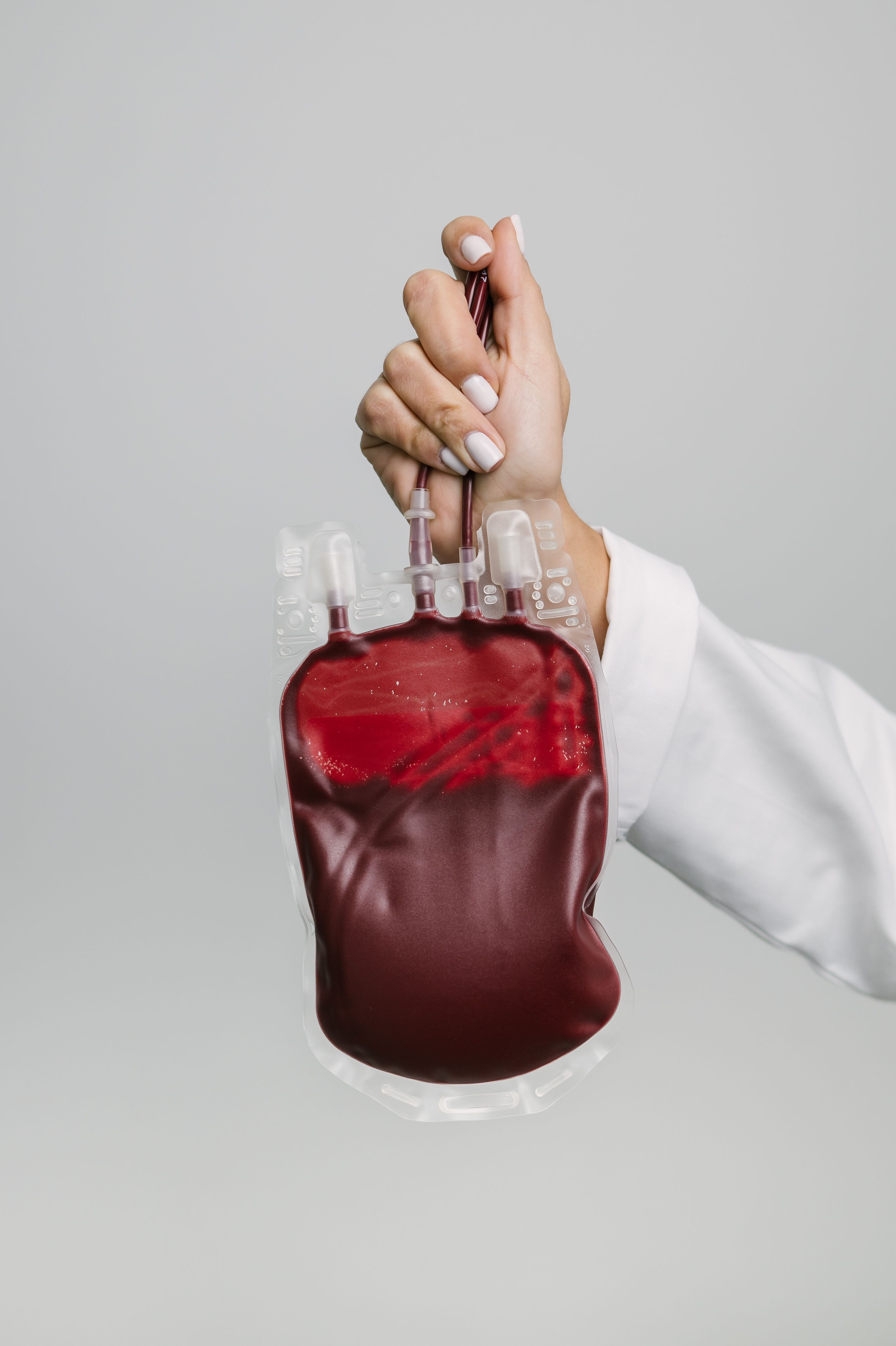 Mão a segurar uma bolsa de sangue.